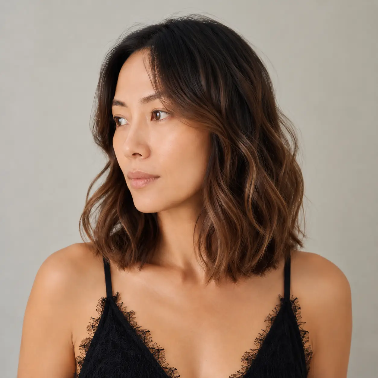 Wavy brunette lob with a soft ombre melting to lighter, warmer ends
