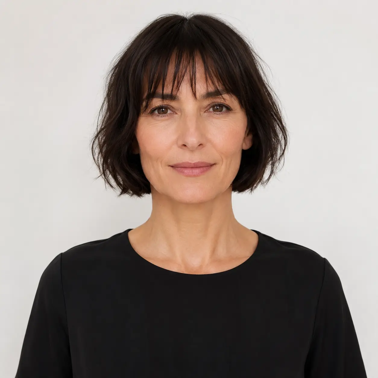Dark French bob with a blunt fringe, chic and compact on fine hair over 50