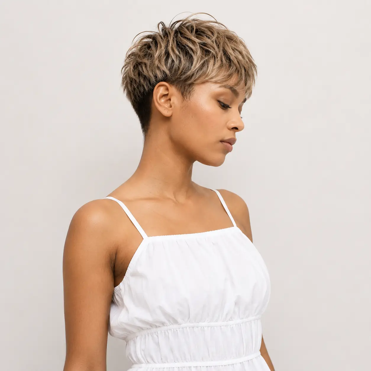 Undercut pixie haircut with shaved sides and textured volume on top for a high-contrast edge