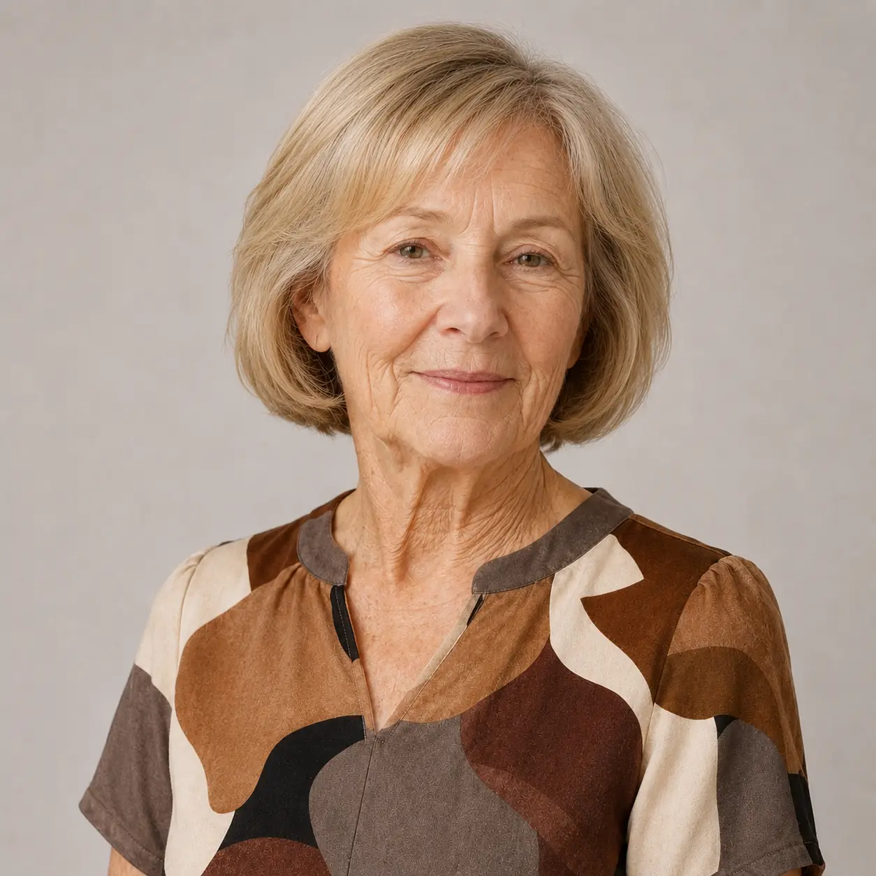 A muted blonde chin-length bob with bangs is a classic choice on a woman over 70