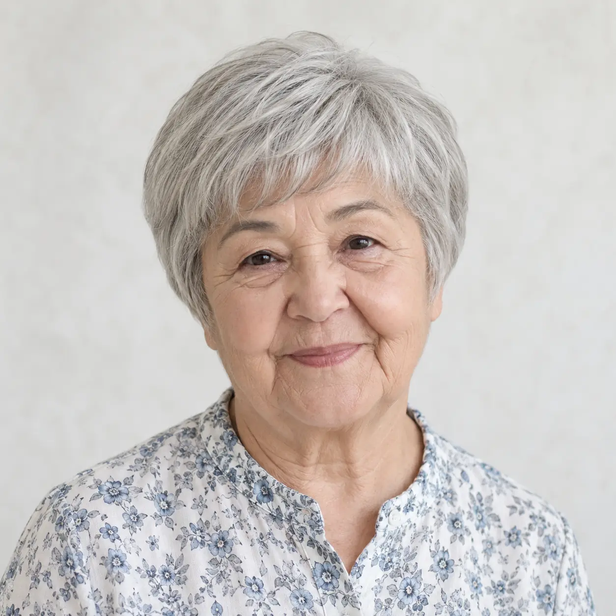 A rounded pixie and wispy fringe give this silver style a gentle face-framing shape, and the curved outline helps mellow angular features